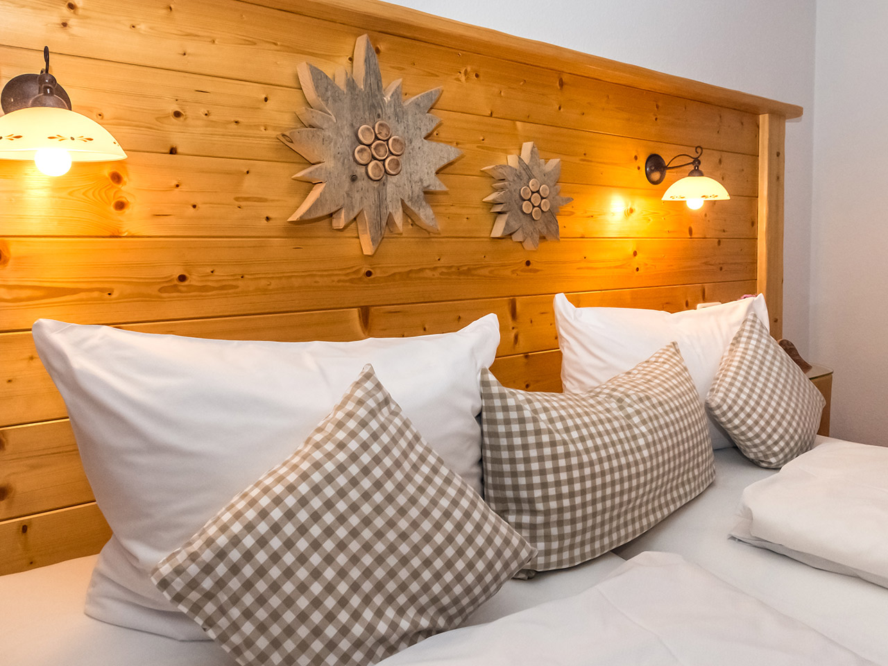Bett mit Holzrückwand im Appartement Maximilian